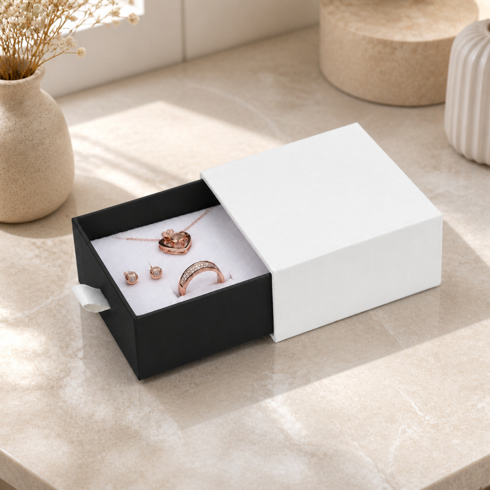 Black drawer jewelry box with ring, earrings and pendant in an elegant jewelry boutique scene.