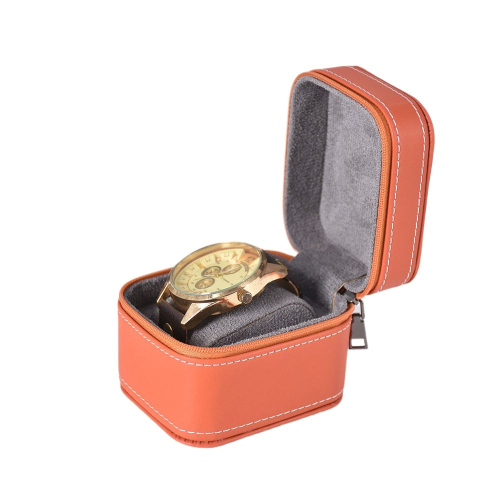 Single timepiece storage case in orange with cushioned protection on a white background.