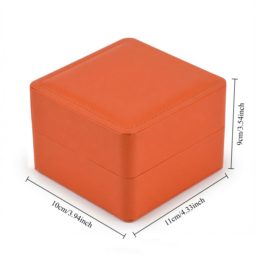 Orange wristwatch gift packaging case featuring a hinged lid and clean white interior.