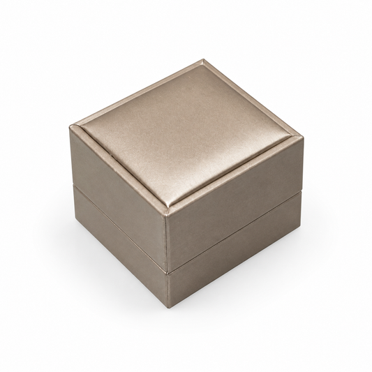 Closed champagne PU ring box on a white background