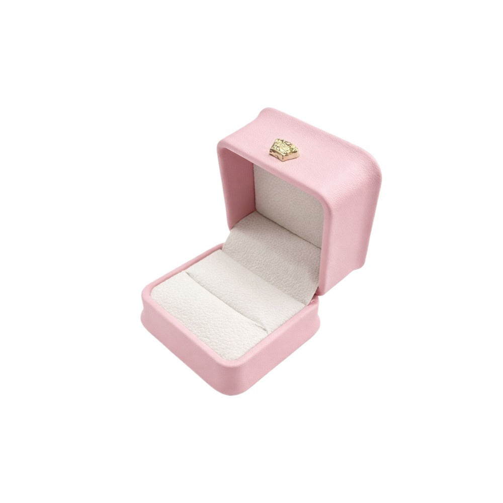 Open pink rounded-corner ring box with a white cushioned insert and gold-tone accent.