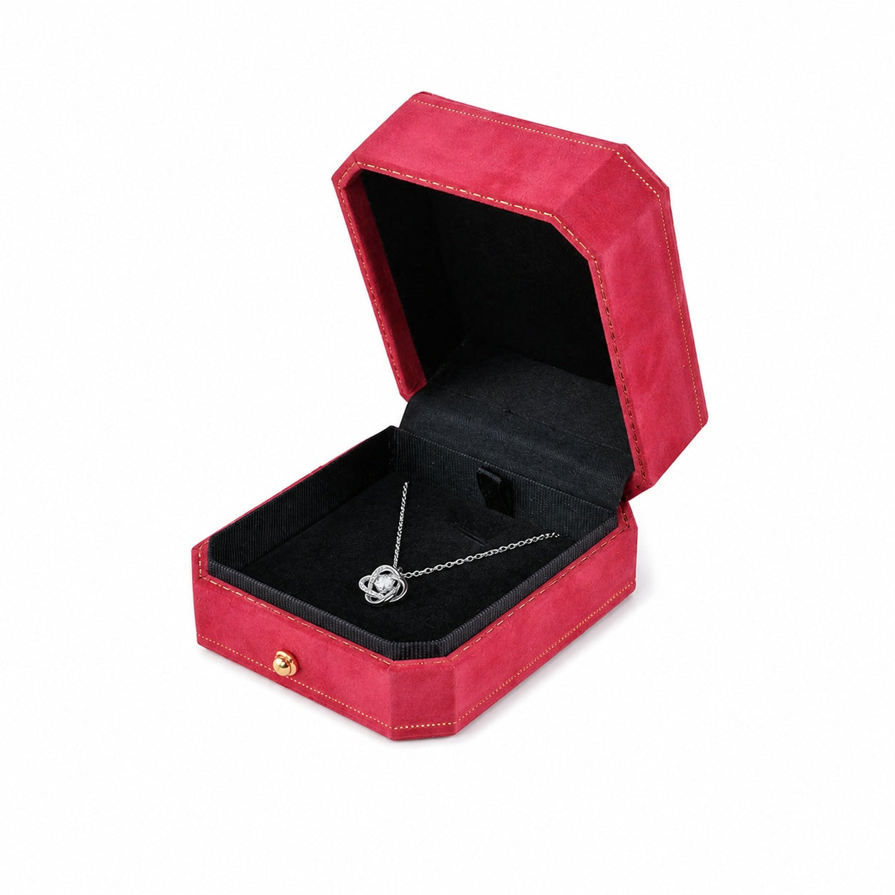 One open red octagonal velvet pendant box displaying jewelry