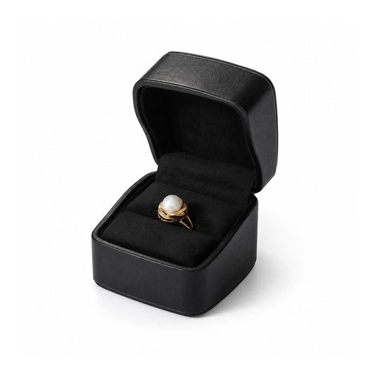 Black ring box with rounded corners and black lining, displaying a pearl ring.