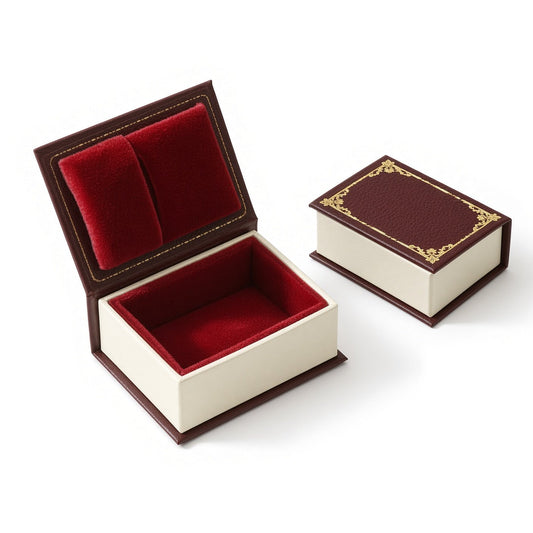 Burgundy book-shaped ring box with red ring cushion and matching closed box on white