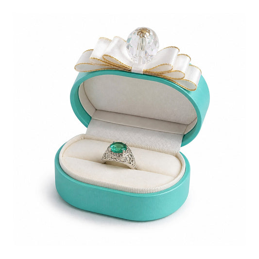 Turquoise oval ring box with a white bow, crystal accent and gemstone ring.