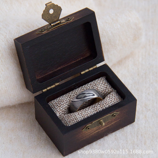 Dark wooden ring box shown open and closed with brass latch and burlap insert